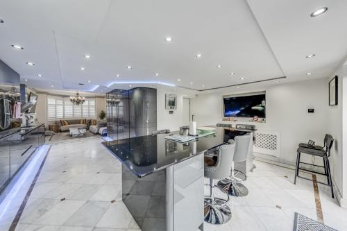 a kitchen with a black counter top and a living room at Chingford Manor in Chingford