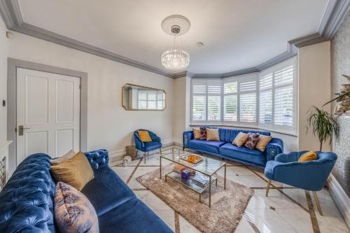 a living room with blue couches and a table at Chingford Manor in Chingford