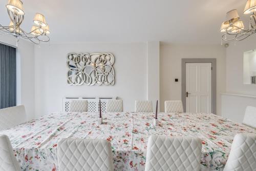 a white dining room with a table and chairs at Chingford Manor in Chingford