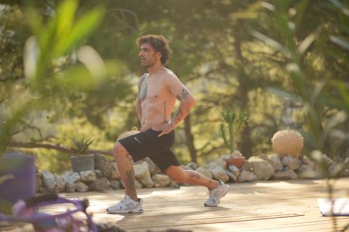 a man with no shirt on standing on a path at Ramitos Hotel in Turunc