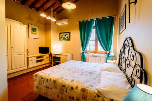 a bedroom with a bed and a desk and a window at Bio Agriturismo Il Melograno di Banditella Ristorante in Alberese