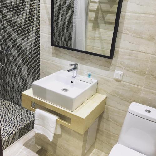 a bathroom with a sink and a toilet and a mirror at Orynbor Boutique Hotel in Astana
