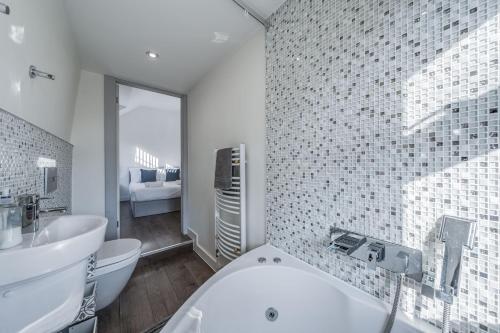 a bathroom with a white tub and a sink at Chingford Manor in Chingford