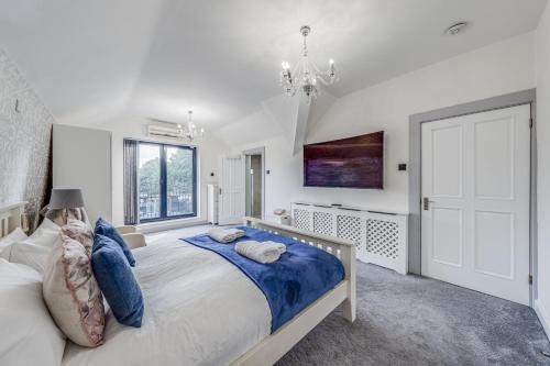 a bedroom with a large bed and a chandelier at Chingford Manor in Chingford