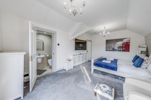 a white bedroom with a bed and a bathroom at Chingford Manor in Chingford