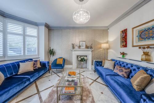 a living room with blue couches and a fireplace at Chingford Manor in Chingford