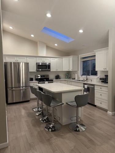 a kitchen with a large island with chairs in it at Spacious 5BR Walk to Wild Waves! in Federal Way