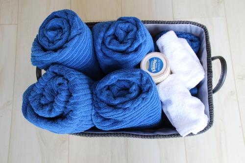 a basket filled with blue towels and a pile of towels at Waiotoi - The Bush Hideaway in Matapouri
