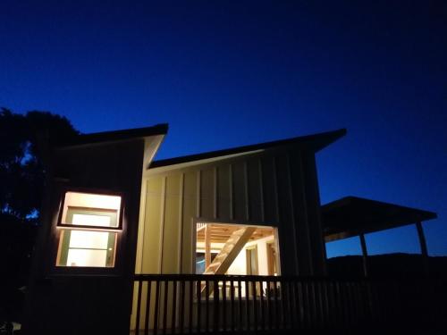 a house with a pitched roof at night at Waiotoi - The Bush Hideaway in Matapouri