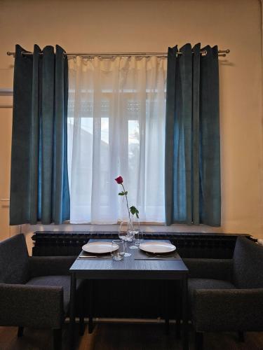 a table with two chairs and a vase with a flower on it at Studio 28 