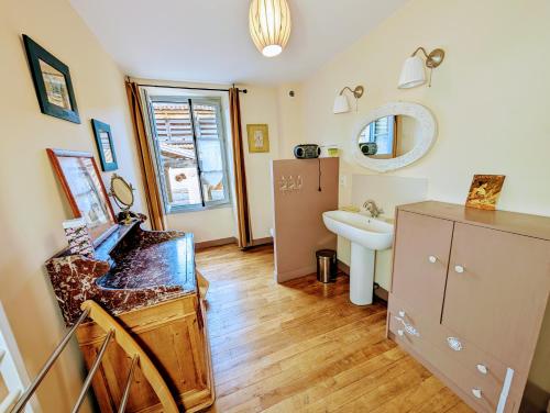 LusignanMaison Galice à Lusignan village médiéval - Base loisir gratuite- 30 min Futuroscope的浴室配有盥洗盆、镜子和台面