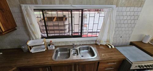 a kitchen counter with a sink and a window at Authentic Suriname in Paramaribo
