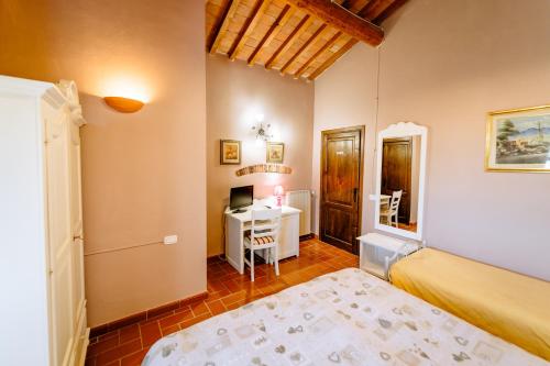 a bedroom with a bed and a desk at Bio Agriturismo Il Melograno di Banditella Ristorante in Alberese