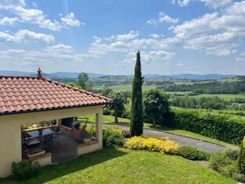 une maison avec patio et vue sur la campagne dans l'établissement Charme du Velay : Maison de caractère avec cheminée, terrasse et équipements bébé à St-Paulien - FR-1-582-266, à Saint-Paulien