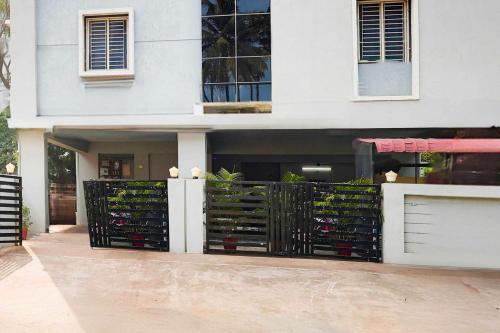 a white house with a gate with wine bottles at Hotel O Kakinada near JNTU in Kākināda