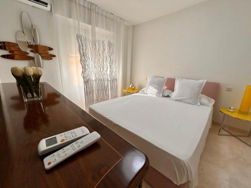a bedroom with a bed and a remote control on a table at Cisneros Royal in La Zubia