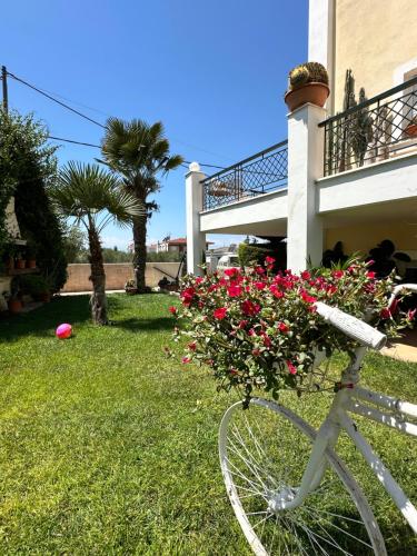 a bike parked in the grass next to a house with flowers at CactusHome in Epanomi
