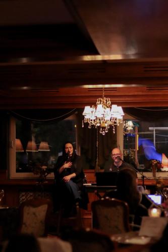 two men sitting in a room with a chandelier at Hotel Ritta Höppner in Gramado