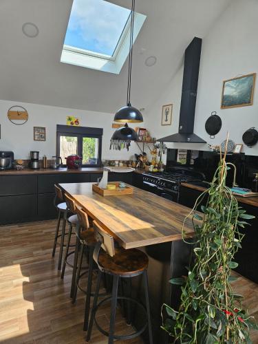 une cuisine avec une table en bois et quelques chaises dans l'établissement Maison proche Boulerie Jump Savigné l'évêque, proche Circuit 24h, à Saint-Corneille