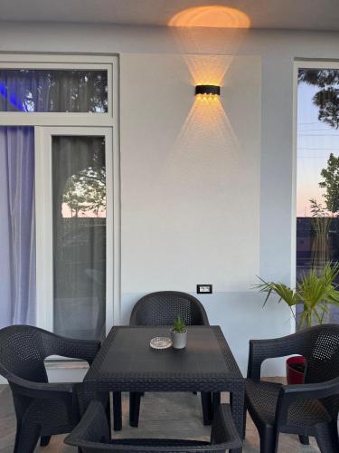 a black table with chairs and a light on a patio at A3 Apartments in Velipojë