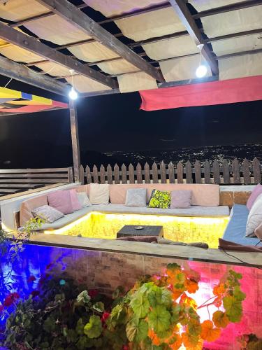a hot tub in a room with a couch and flowers at شاليه بانا جرش in Jerash