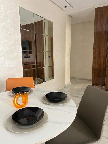 a white table with two chairs and an orange ribbon on it at Very nice modern air-conditioned apartment in Fez in Fès