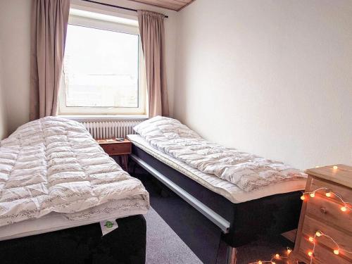 two twin beds in a room with a window at 4 star holiday home in Brønderslev in Brønderslev
