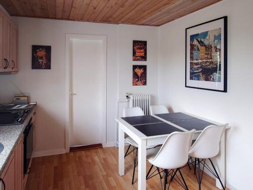 a kitchen with a white table and white chairs at 4 star holiday home in Brønderslev in Brønderslev