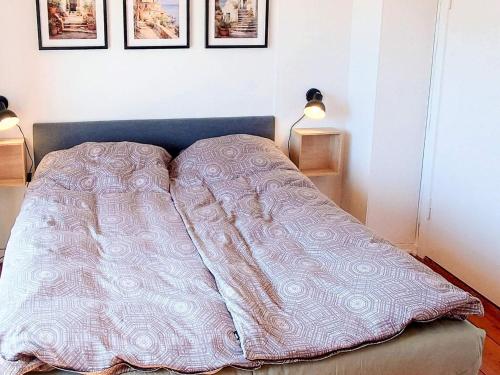 a bed with a blanket on it in a room at 4 star holiday home in Brønderslev in Brønderslev