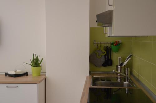 a kitchen with a sink and green tiles at Lierna Beach Apartments in Lierna