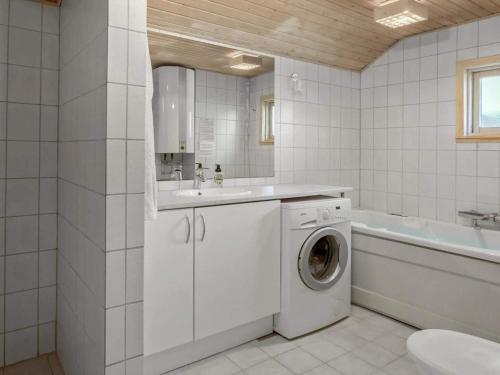 une salle de bain blanche avec une machine à laver et une baignoire dans l'établissement 8 person holiday home in Rødby, à Rødby