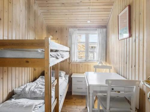 une chambre avec deux lits superposés et une table dans l'établissement 8 person holiday home in Rødby, à Rødby