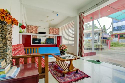 a living room with a table and a chair at Hotel O Dream Palace in Kovalam