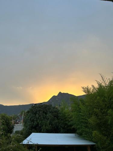 a view of a mountain with a sunset in the background at Hospedaje El Paraíso in San Pedro La Laguna