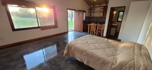 a bedroom with a bed and a kitchen with a table at La Casita del Monte in San Miguel del Monte