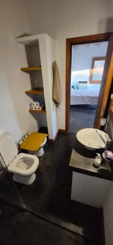a bathroom with two toilets and a sink at La Casita del Monte in San Miguel del Monte