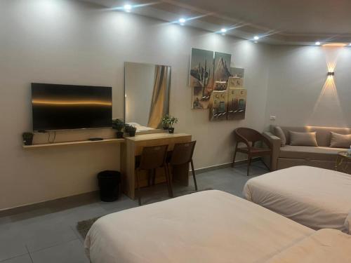 a hotel room with two beds and a flat screen tv at Scandic resort chalet sea view in Hurghada