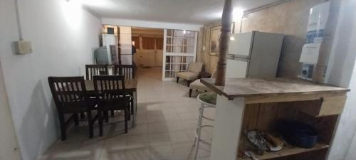 a kitchen with a table and chairs and a refrigerator at BackPakersBasic in Tigre