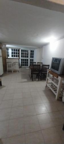 a living room with tables and chairs and a tv at BackPakersBasic in Tigre