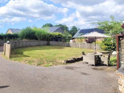 een tuin met een tafel en een paraplu bij Garden Cottage - Cp28 in Halwell
