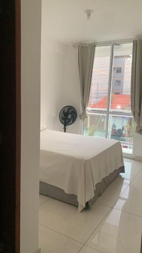 a bedroom with a bed and a large window at Apartamento refúgio tropical in Arraial do Cabo