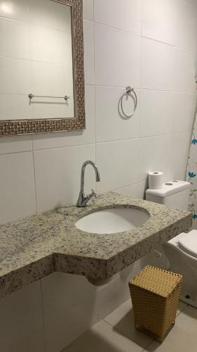 a bathroom with a sink and a toilet at Apartamento refúgio tropical in Arraial do Cabo