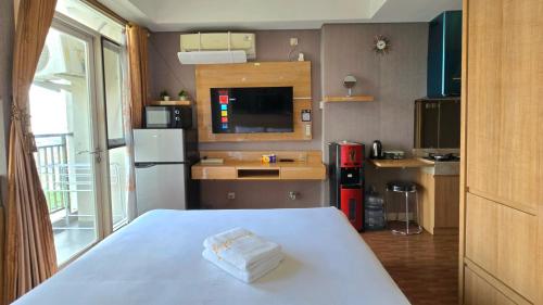 a small kitchen with a table and a refrigerator at Studio Apartment JiExpo Kemayoran View -Min Stay 3 nights- in Jakarta