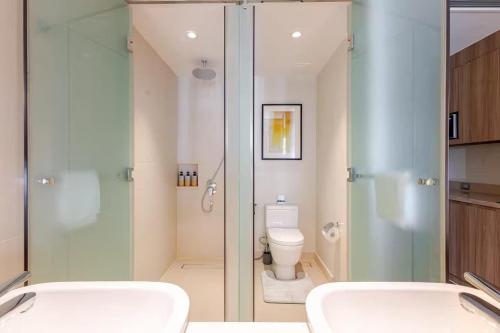 a bathroom with a glass shower and a toilet at Novotel Executive Suite - Acqua Manila Khendra in Manila