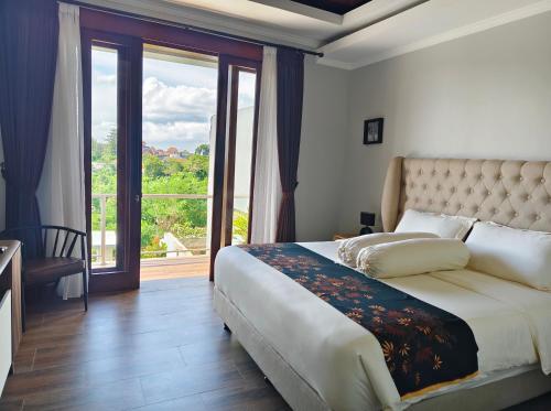 a bedroom with a large bed and a large window at villa nusantara ungasan in Uluwatu