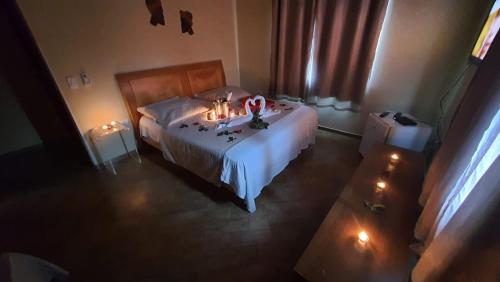 a bedroom with a bed with candles on it at Recanto Da Mata in Morretes