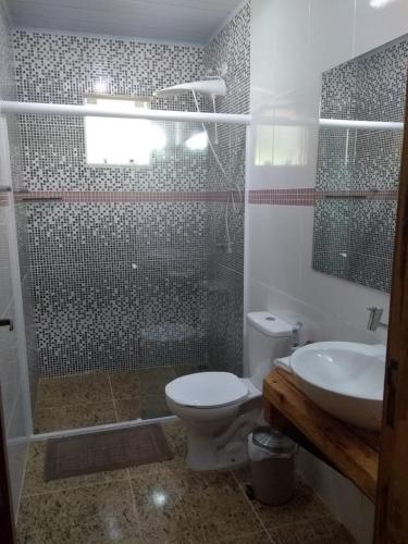 a bathroom with a shower and a toilet and a sink at Recanto Da Mata in Morretes