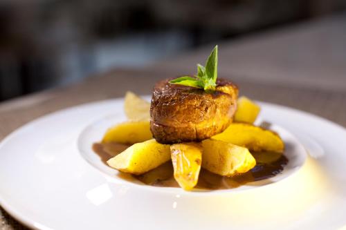 a plate of food with a piece of meat on top at Grande Hotel Petrópolis in Petrópolis