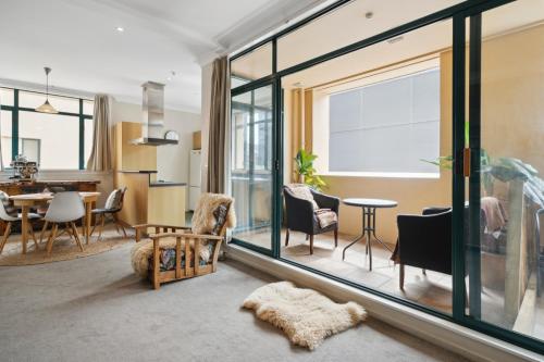 a living room with a large window and a dining room at Spacious, 2 Bed, 2 Bath Central City Retreat in Wellington