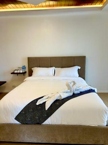 a bedroom with a bed with towels on it at Castle View Hotel Samal in Magamomo